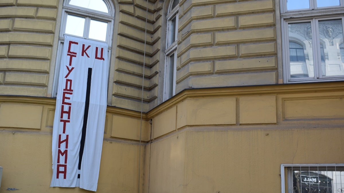 A sign hanging from the side of a building